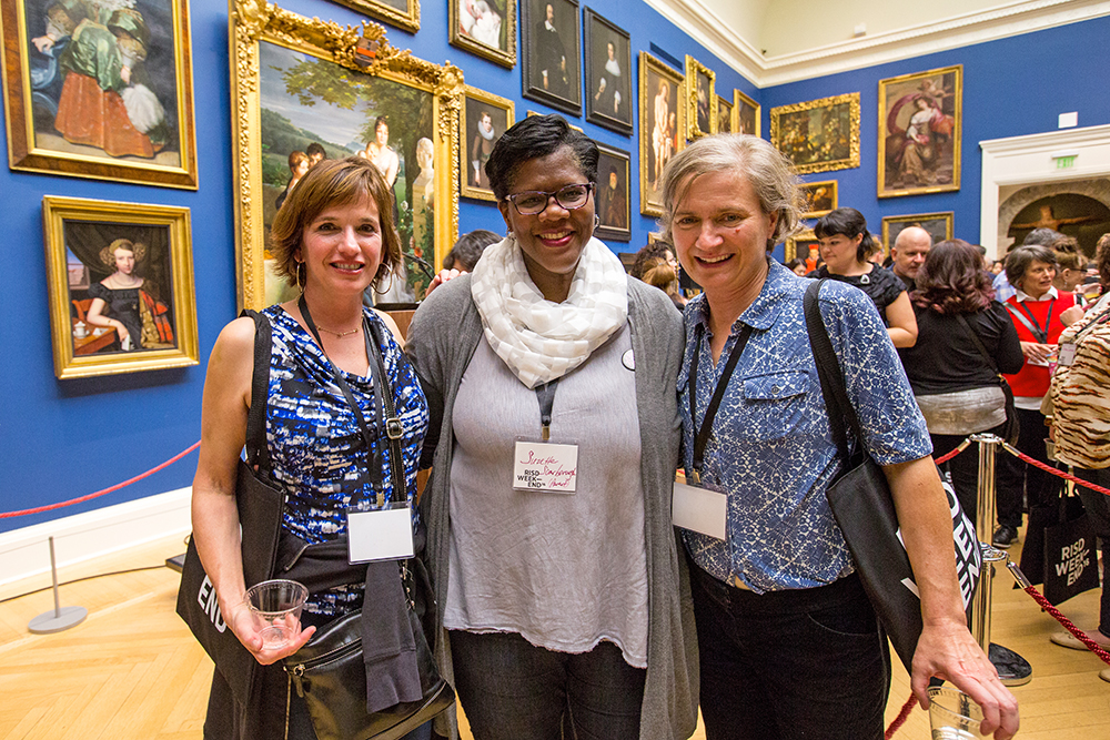 Three alumni posing in the RISD Museum Grand Gallery.