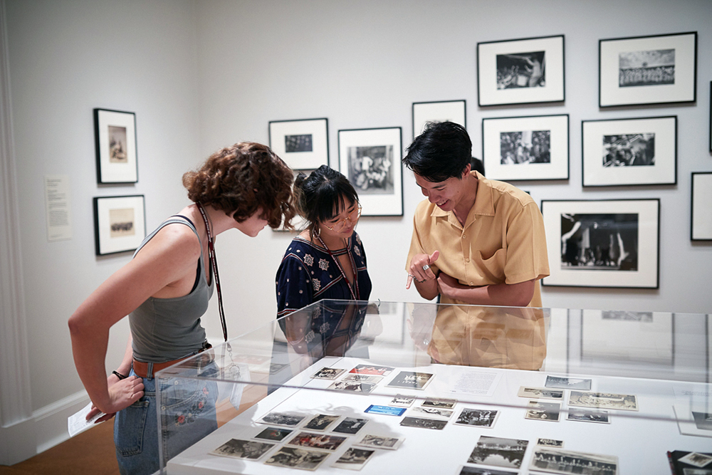 Students looking at photographs in a display at RISD Museum.