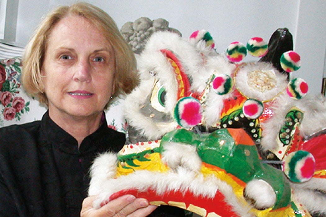 Photo of Judy Bowrering Funkhouse holding a Chinese dragon puppet.