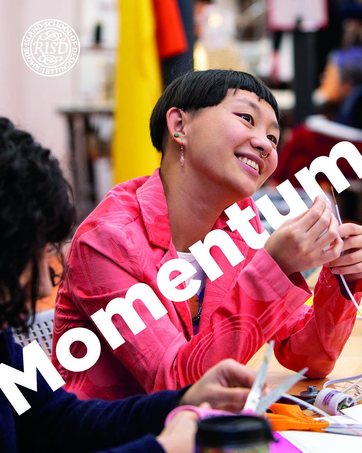 Cover of Momentum magazine with image of a student smiling and sewing
