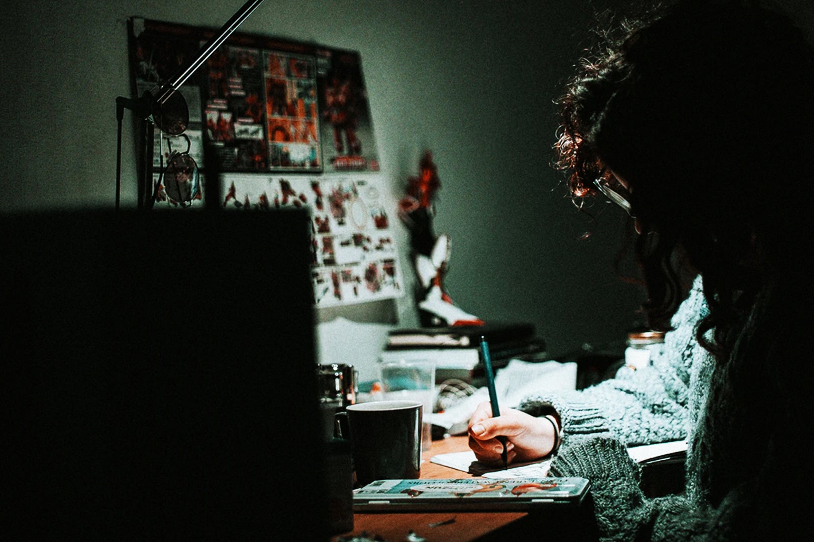 An artist working in a dark lit room.
