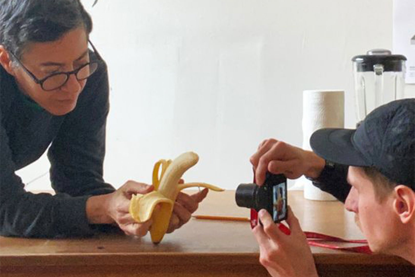 A person taking a photo of a banana.