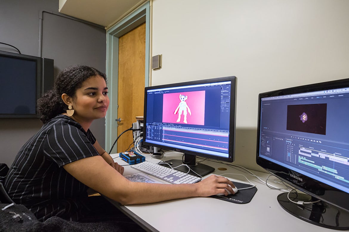 Dairys Escoto working at a computer with two monitors
