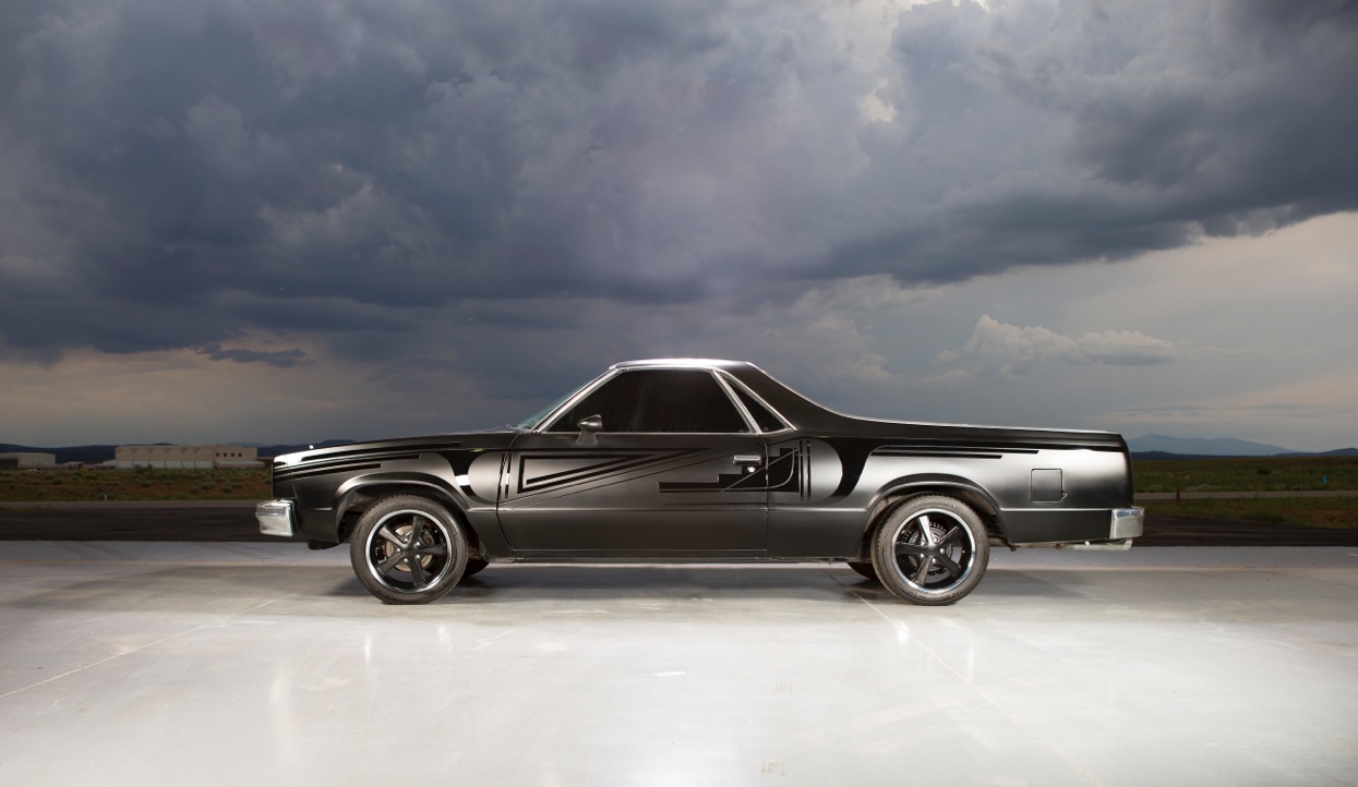 Image of a black and grey an El Camino under a cloudy sky