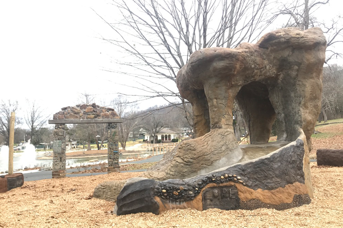 A playground structure made of rock in a park