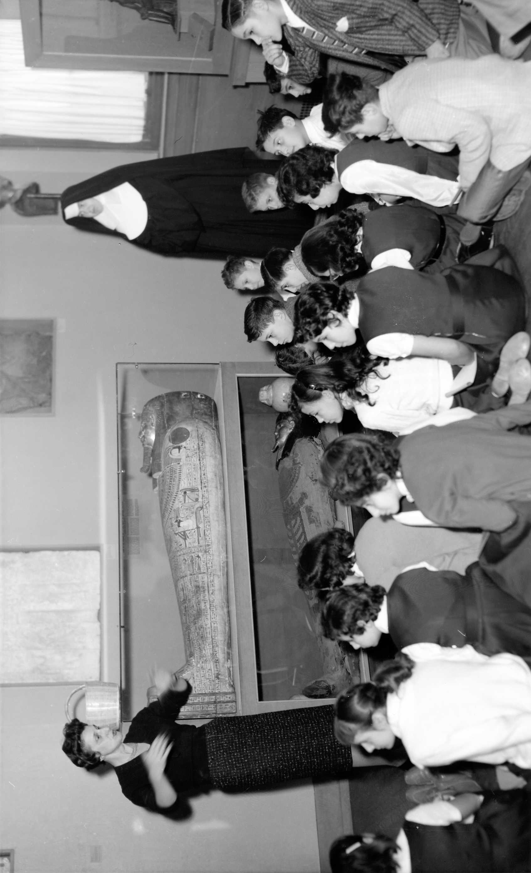 ca. 1955 Docent Pearl Nathan, showing a school group the sarcophagus of Nesmin, 170–30 BCE. Courtesy of the RISD Archives.