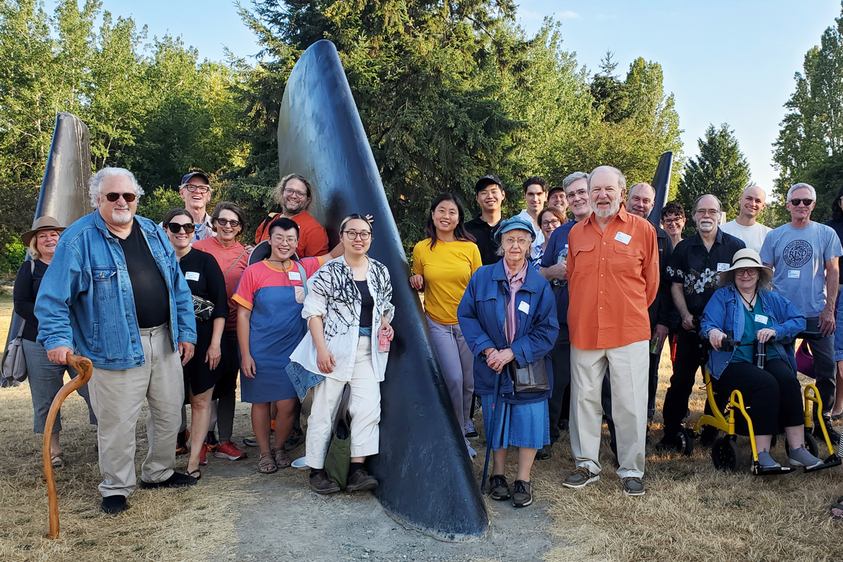 Alums standing at a FIN statue