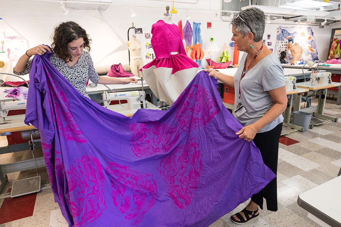Mentor Meg DeCubellis (right) examines a length of cotton that has been screenprinted and hand-dyed by Hajian (left).