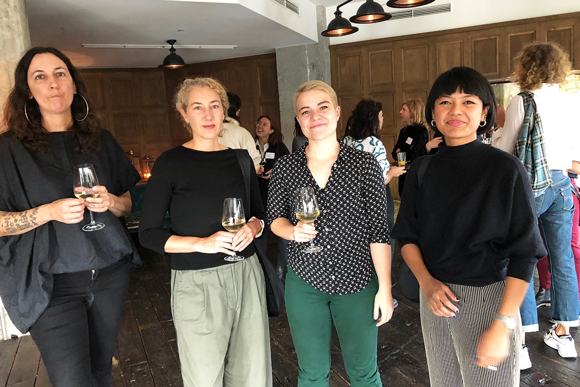 Photo of four alumni standing together at a reception in Berlin