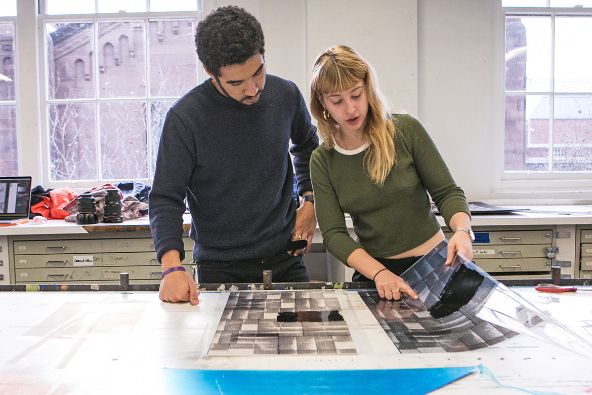 Photo of two people reviewing transparencies. 
