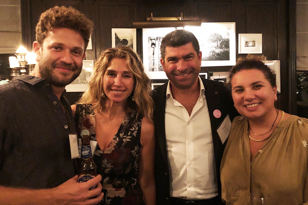 Photo of four alumni standing together at a reception in London