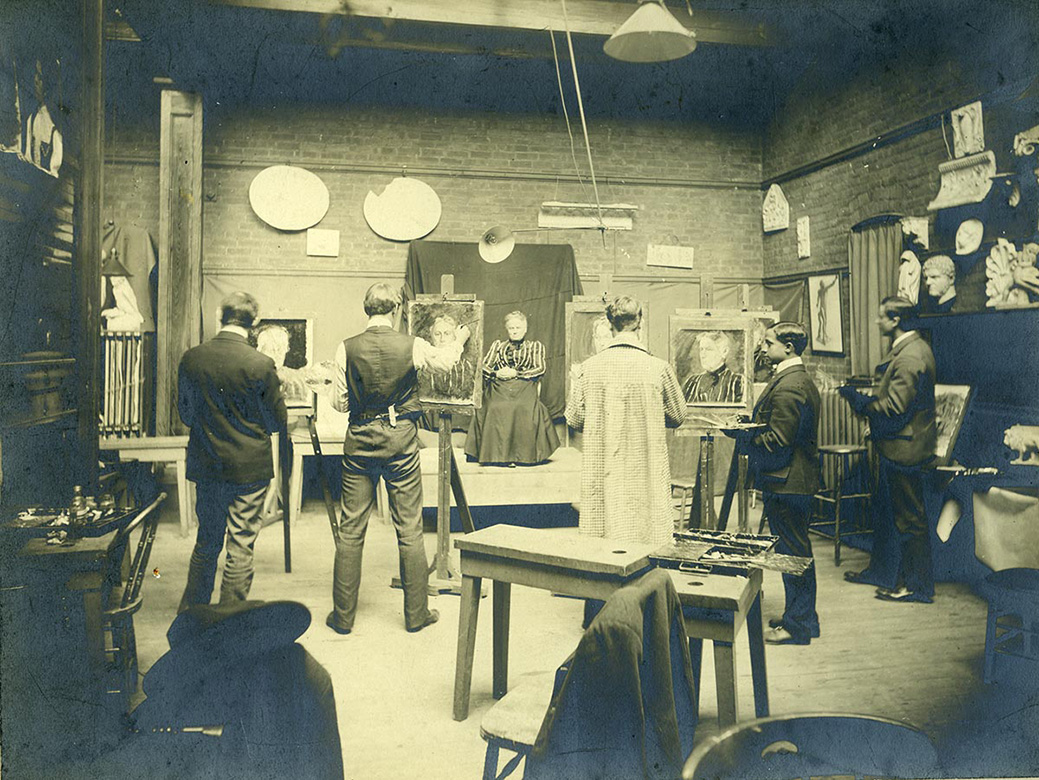 Historic 19th century photo of students painting in a studio.