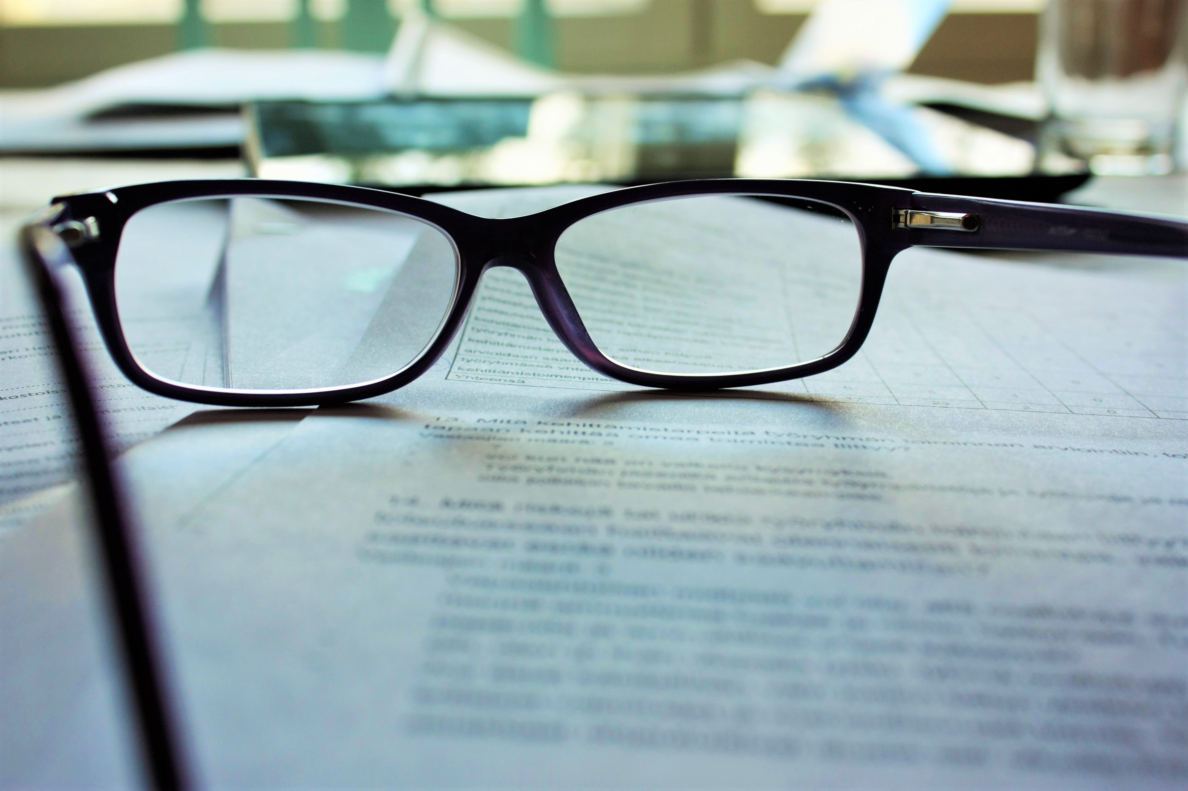 Photo of black framed glasses resting on a printed page