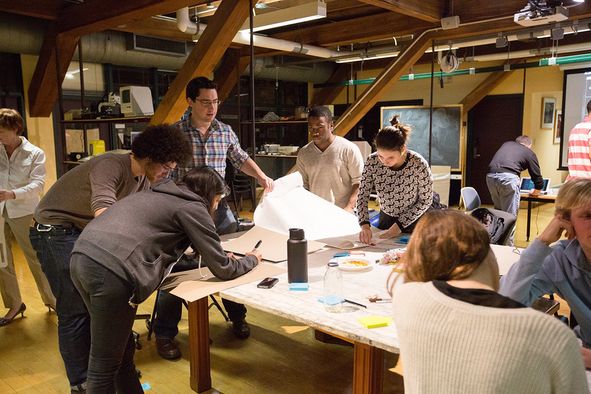 Photo of students working together around a table in a studio.