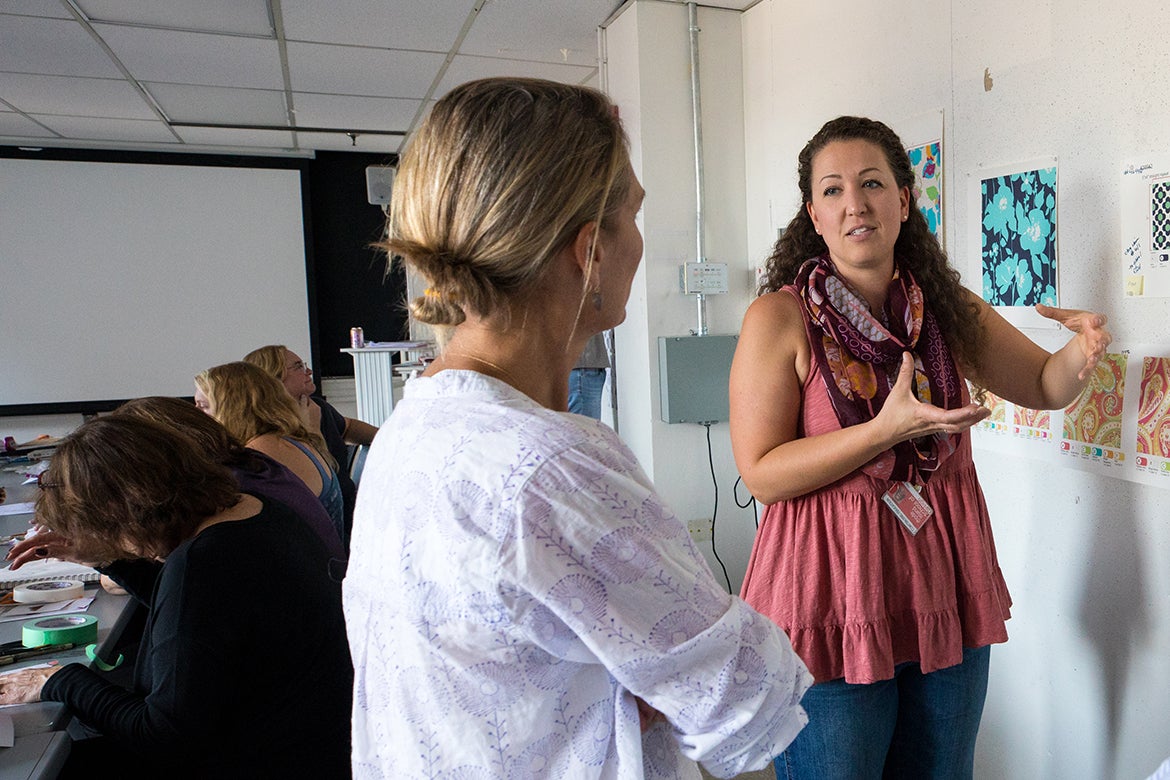 Photo of an instructor discussing artwork with a student