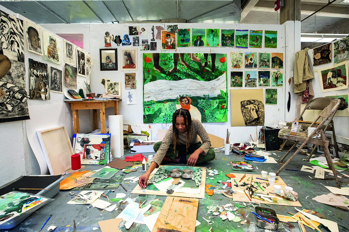 Photo of Sophia-Yemisi Adeyemo-Ross in the studio working on a collage