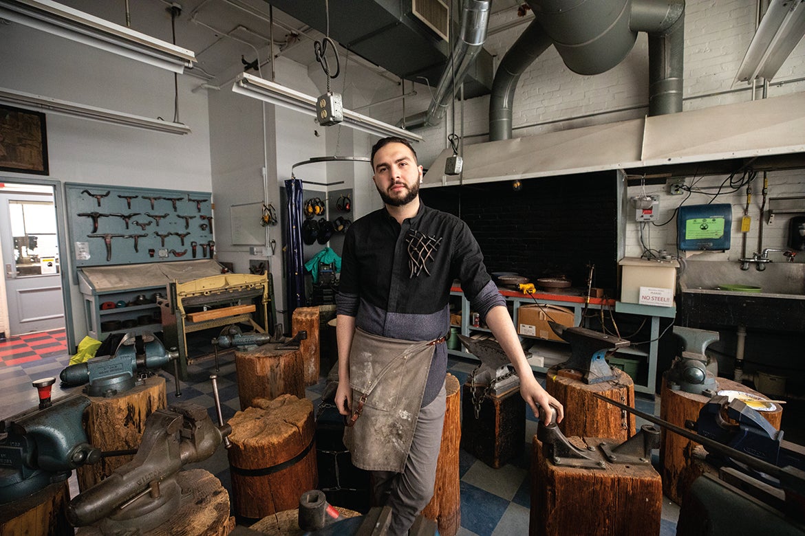Photo of Steven Kaplan-Pistiner in his studio wearing one of his brooches
