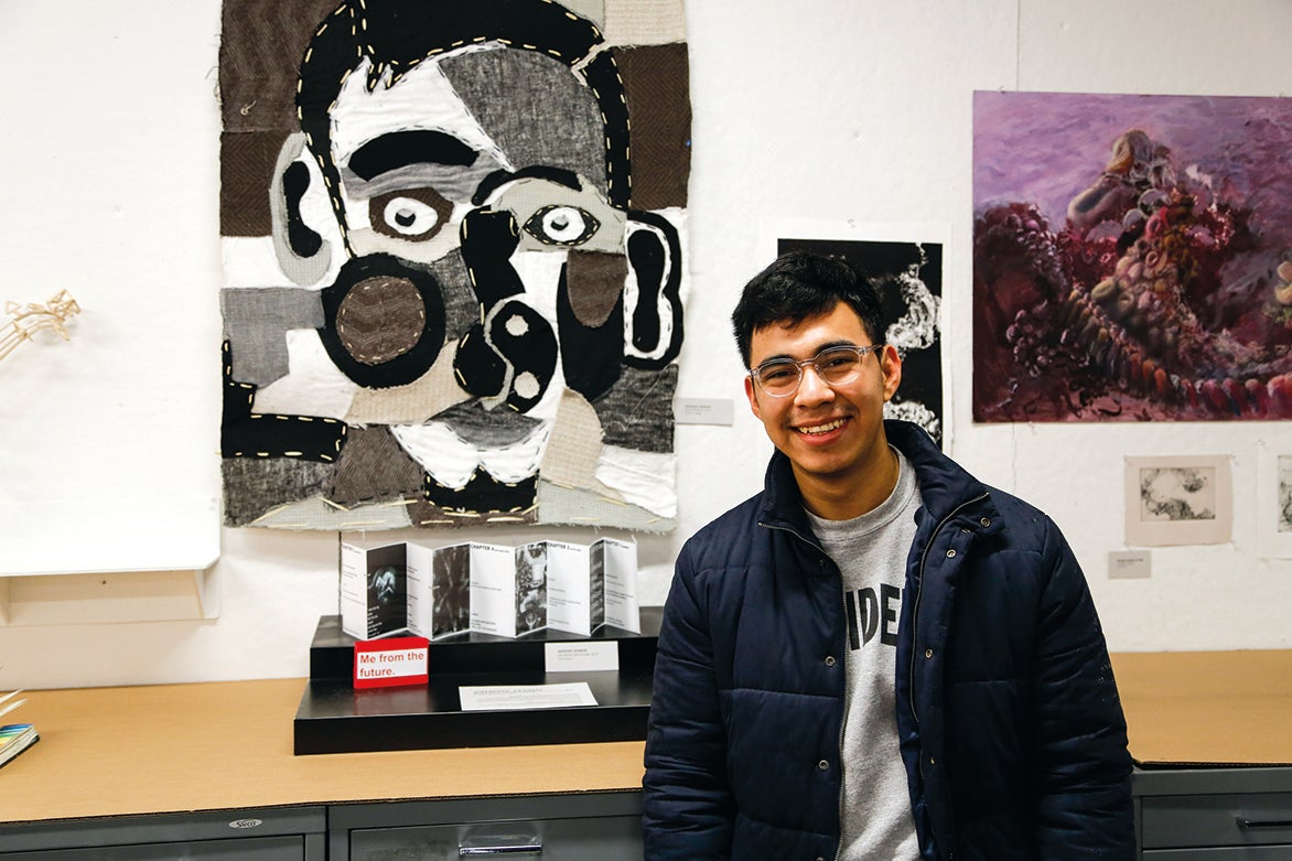 Photo of Anthony Azanon standing in front of artwork.