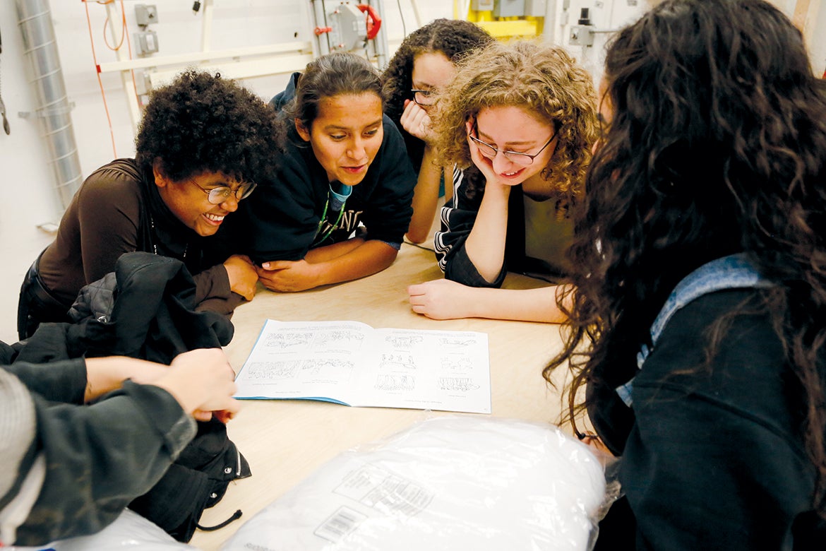 Project Open Door students around a table collaborating on a project.