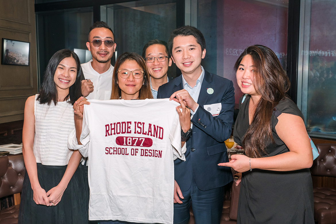 Members of the RISD Club of Hong Kong posing and holding a RISD t-shirt.