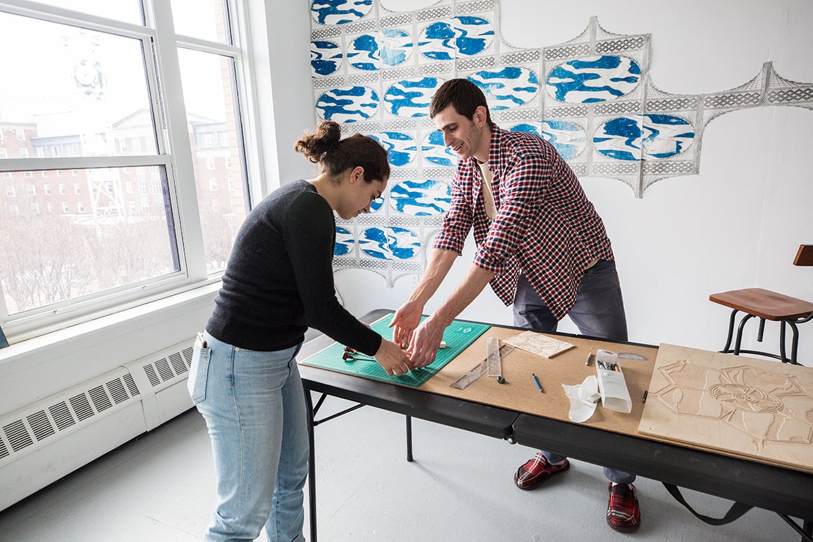 Nick Costantino working with another student in the printmaking studio