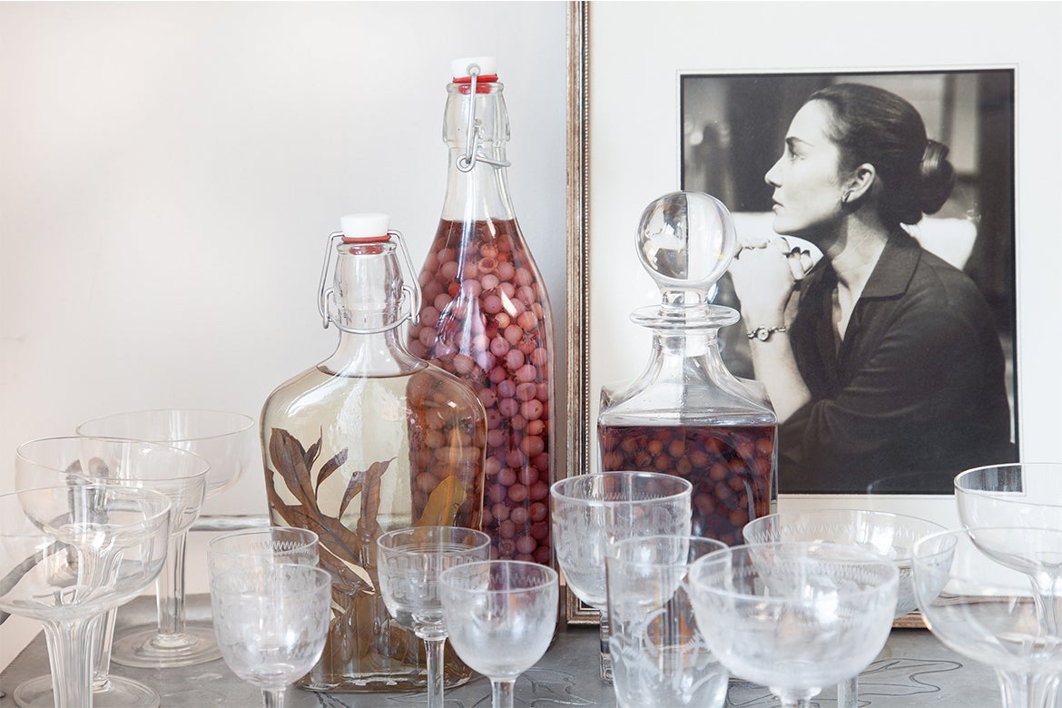 Photo of cocktail glasses in front of a portrait.