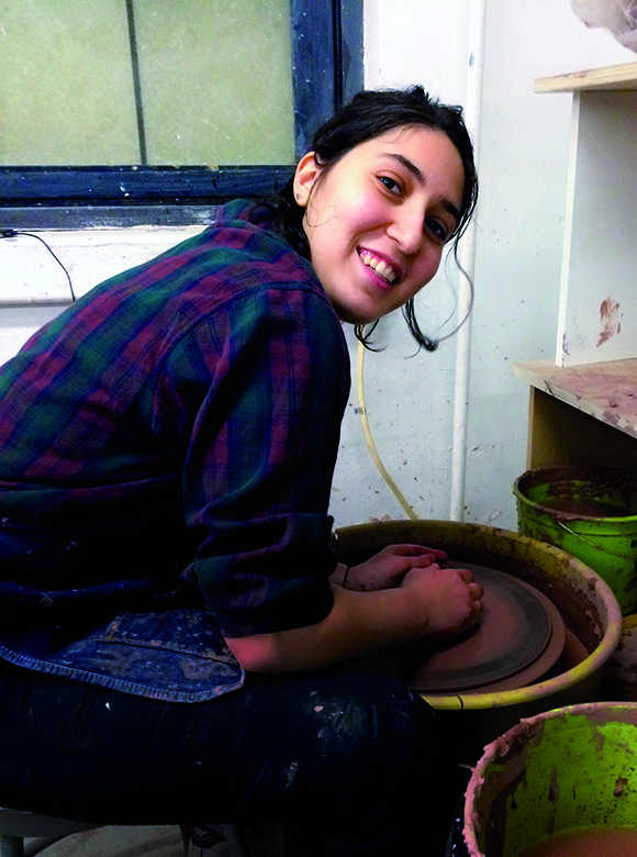 An image of Maddy Parrasch sitting at a pottery wheel