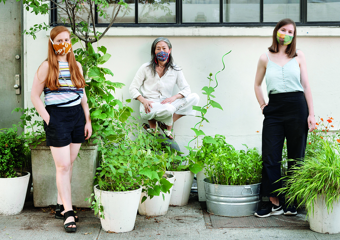 An image of Callie Clayton, Annie Keating and Juliana Sohn standing among some potted plants