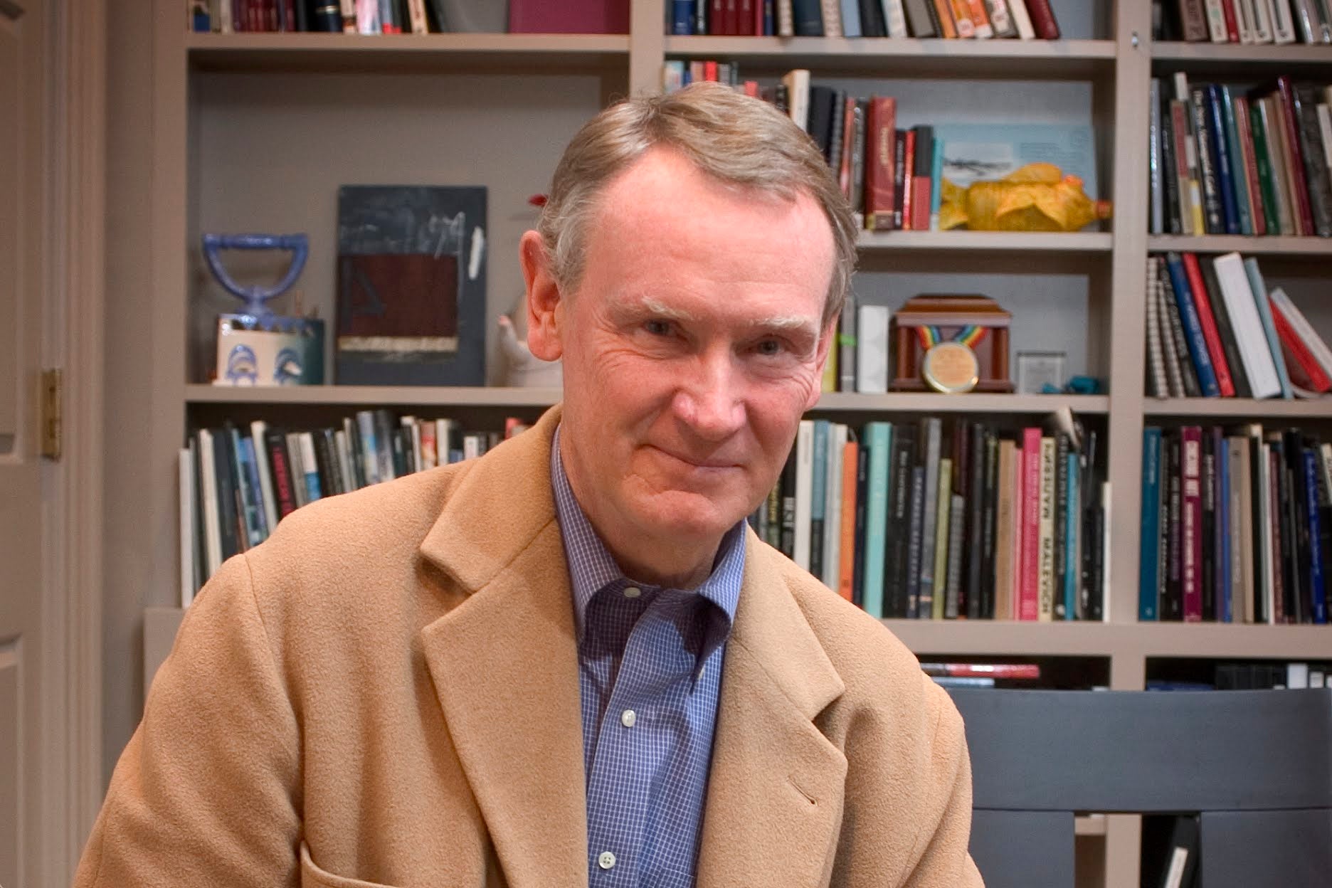 A photo of Roger Mandle, RISD 15th President, in a tan blazer in front of a bookcase.