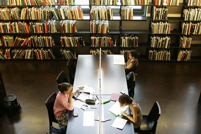 Image of three people in a library 