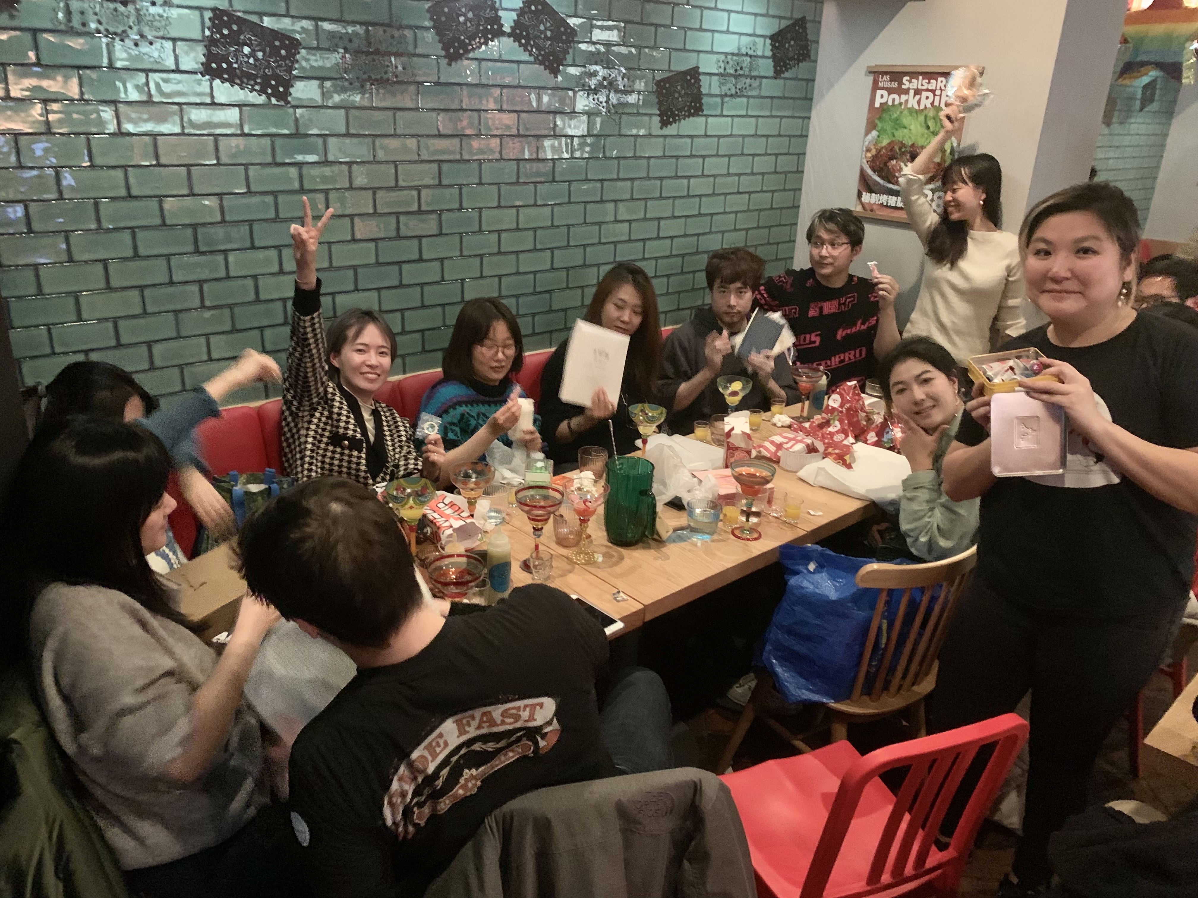 Group of people at a holiday party in a restaurant holding gifts
