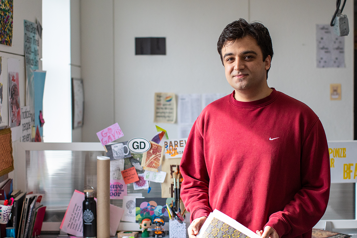 Image of a male with short dark hair and a red sweater