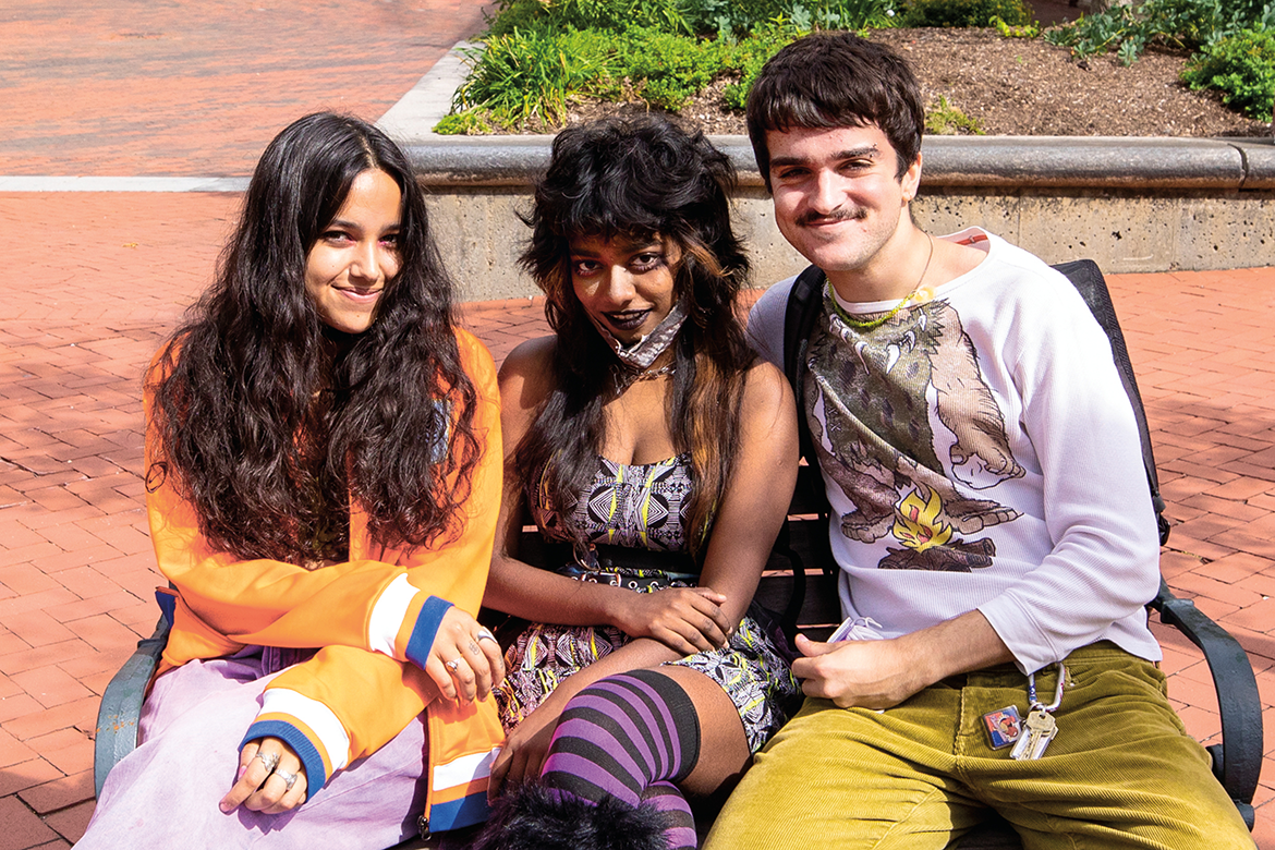 Three students sitting on a bench 