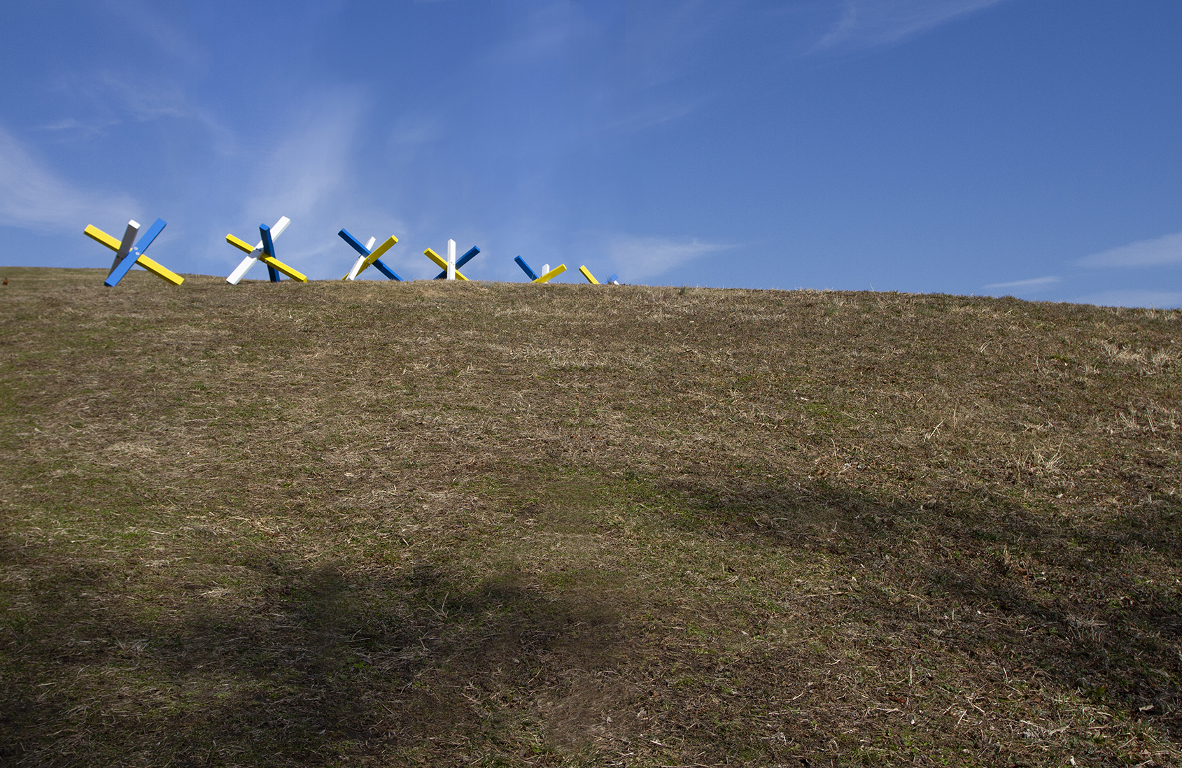 A row of blue, yellow and white structures on a field