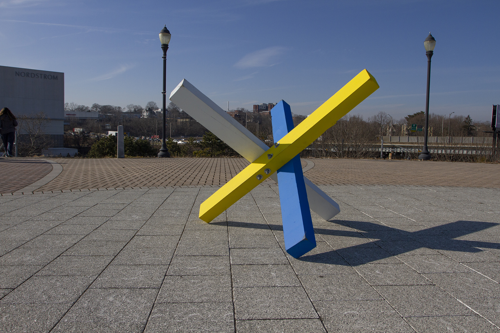 A blue, yellow and white structure on a section of pavement