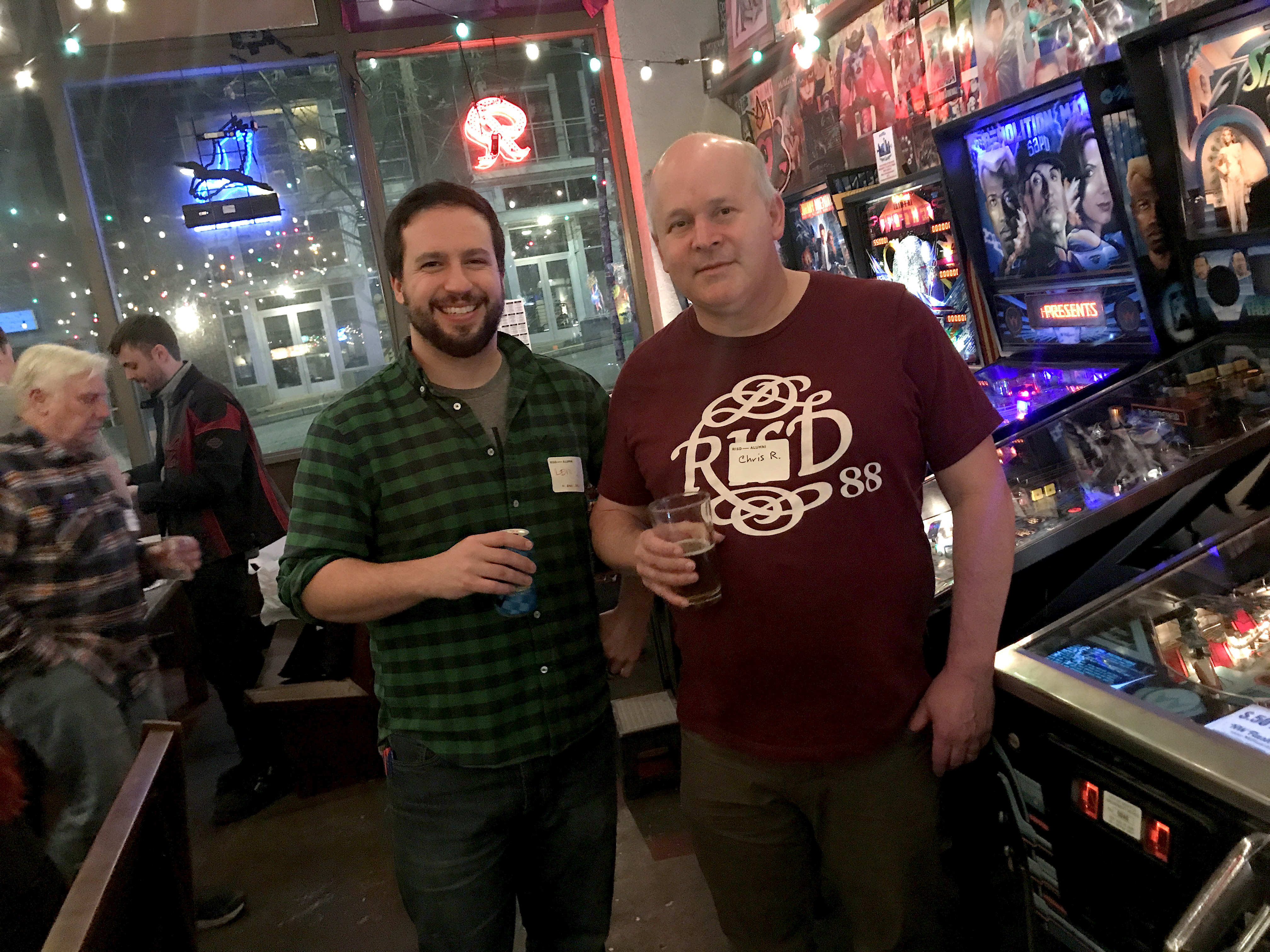 Two men standing in front of pinball machines