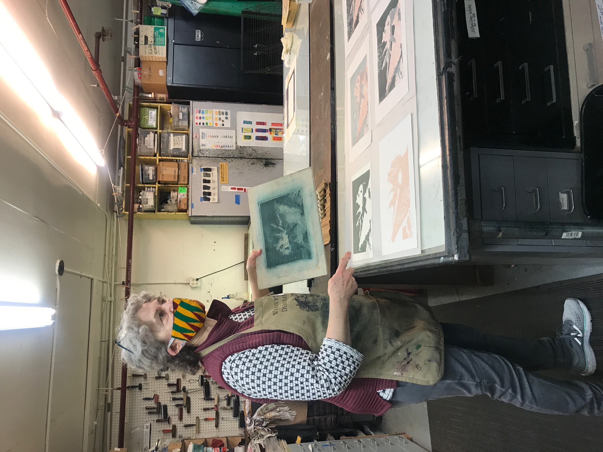 A woman holds a green and white print