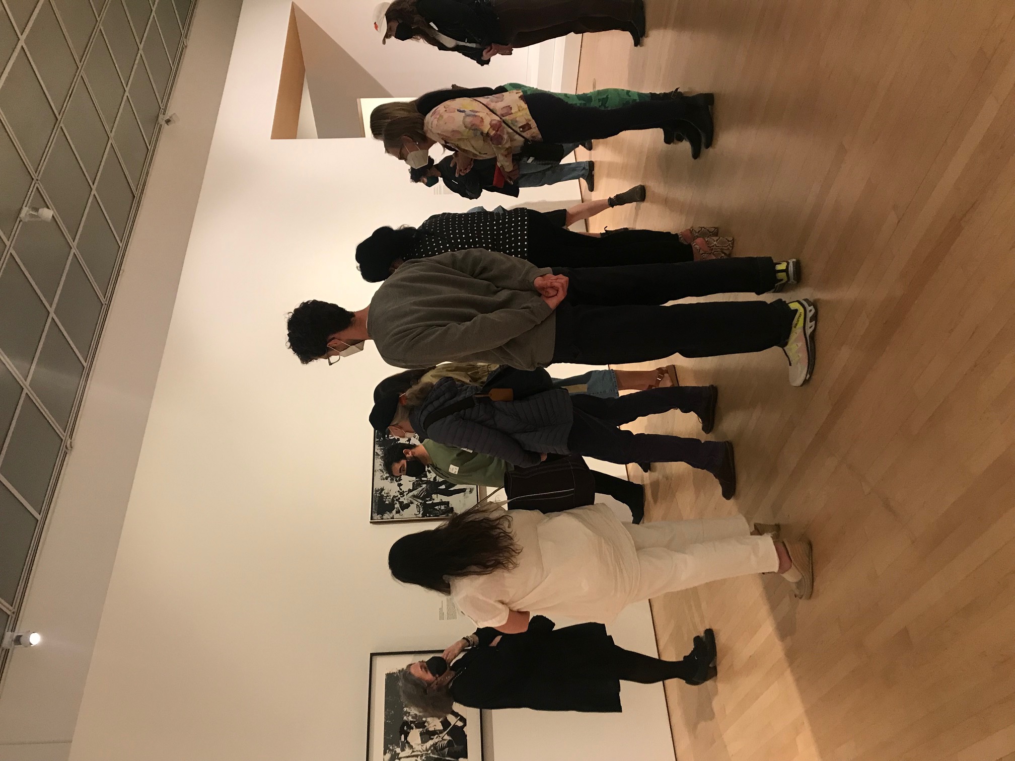 Eleven people standing in a gallery before black and white canvases