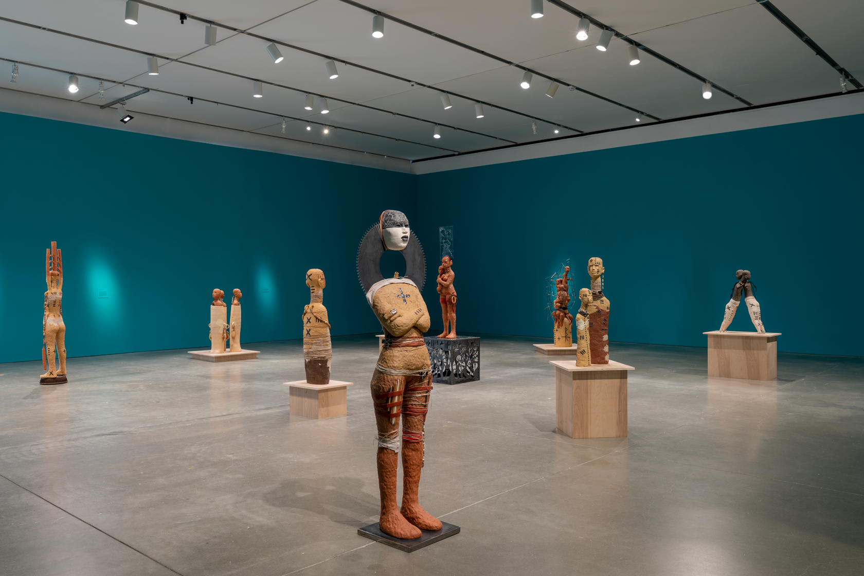 A collection of clay human sculptures in an exhibition hall