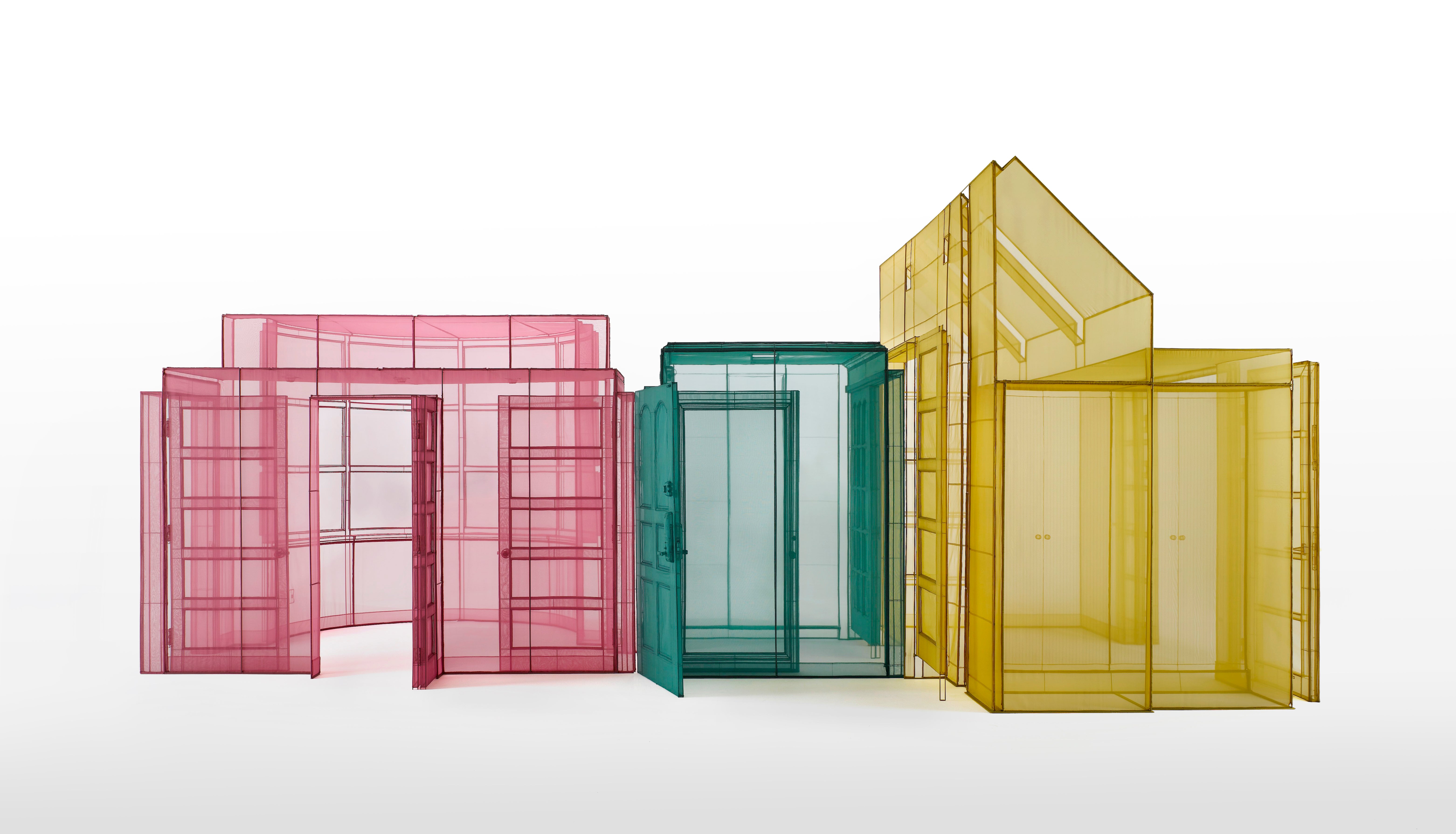 Three house-like structures: one pink, one teal, and one yellow
