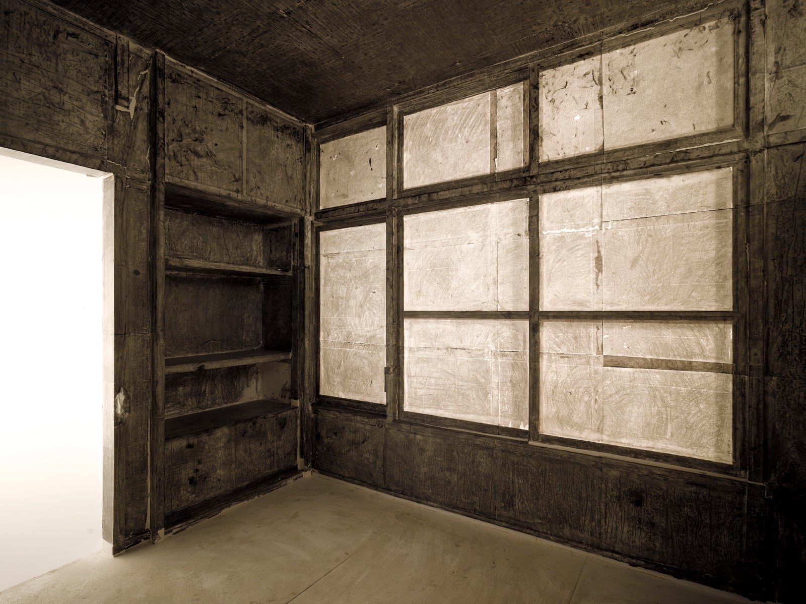 Panels of paper inside a wooden house-like structure