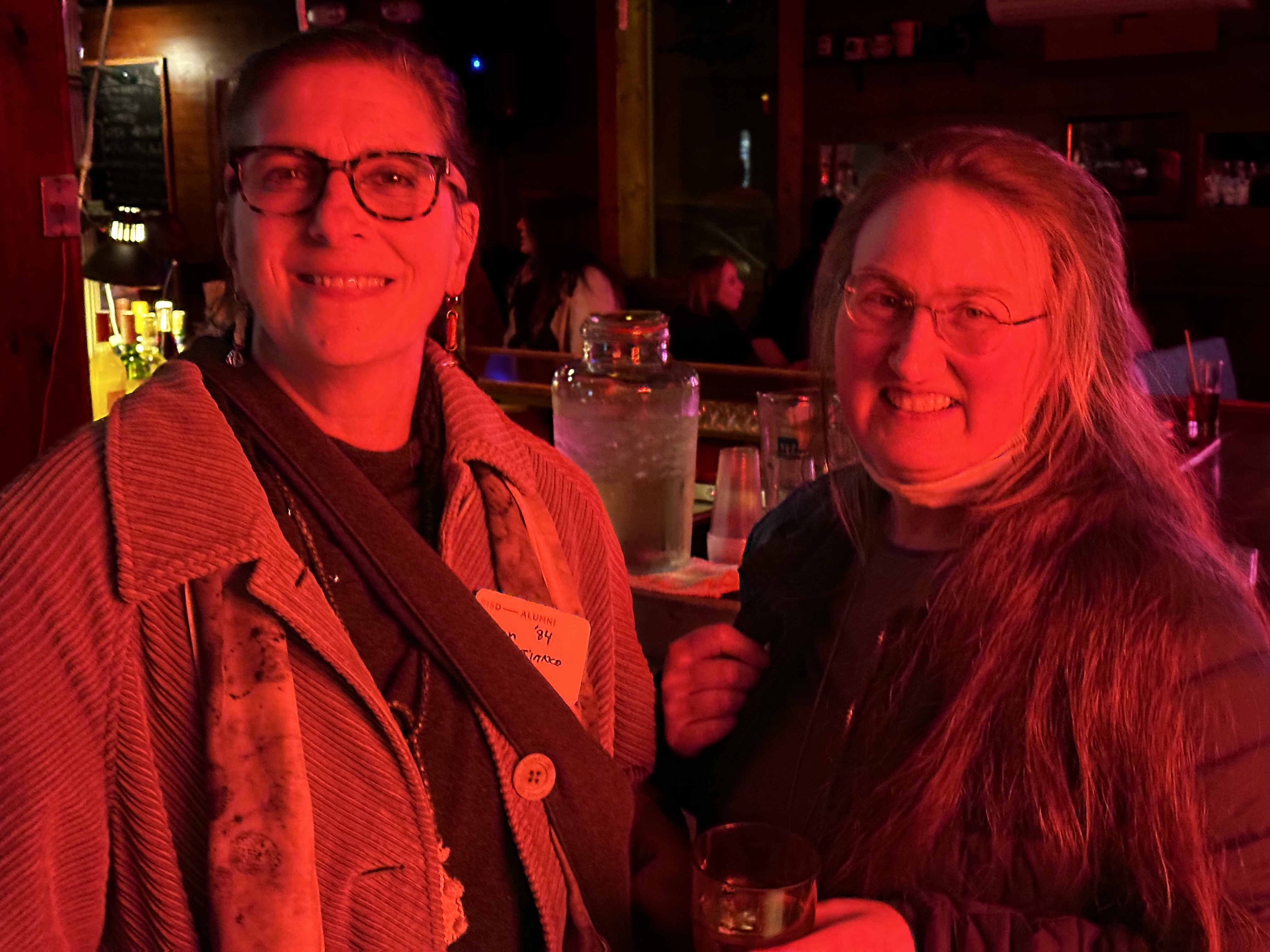 Two people in a bar and smiling at the camera