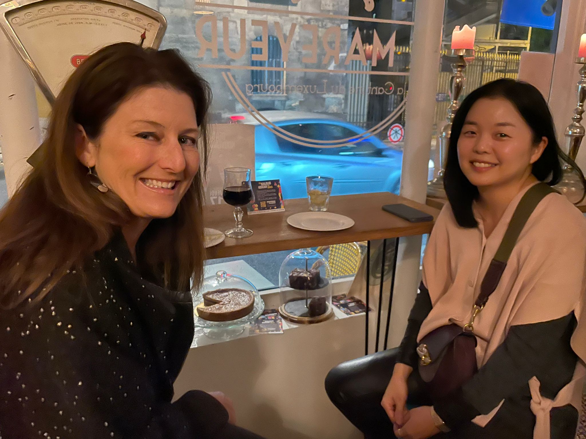 Two people sitting in a restaurant and smiling at the camera