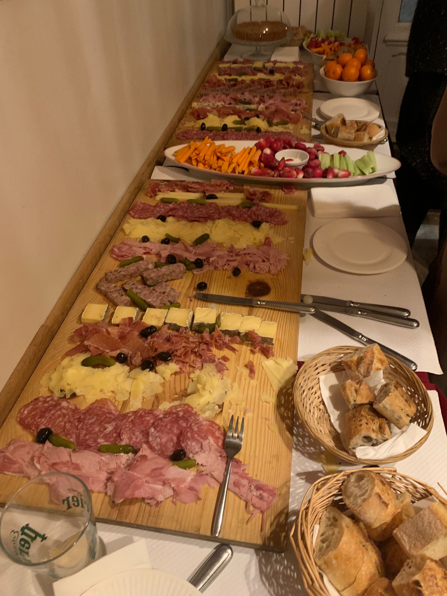 A charcuterie spread that includes cheese, meat, bread, and vegetables