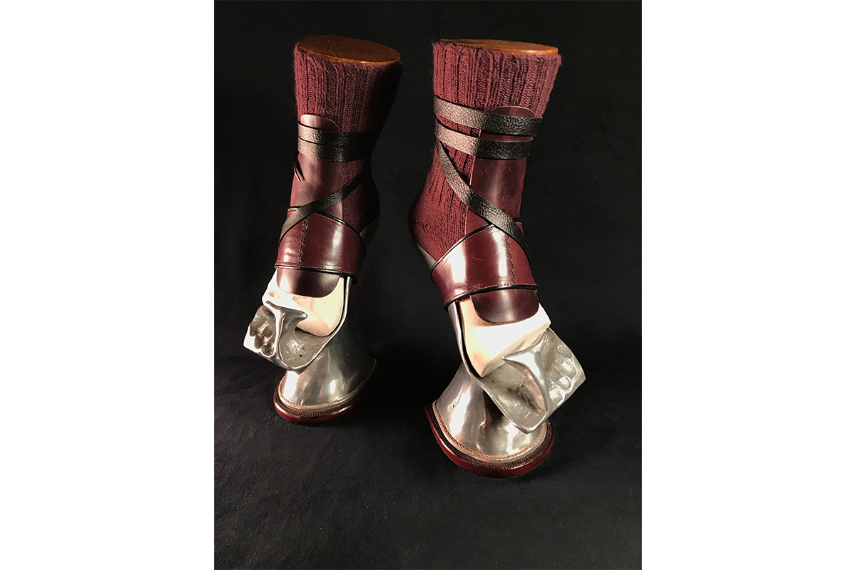 A pair of strappy maroon and gold shoes