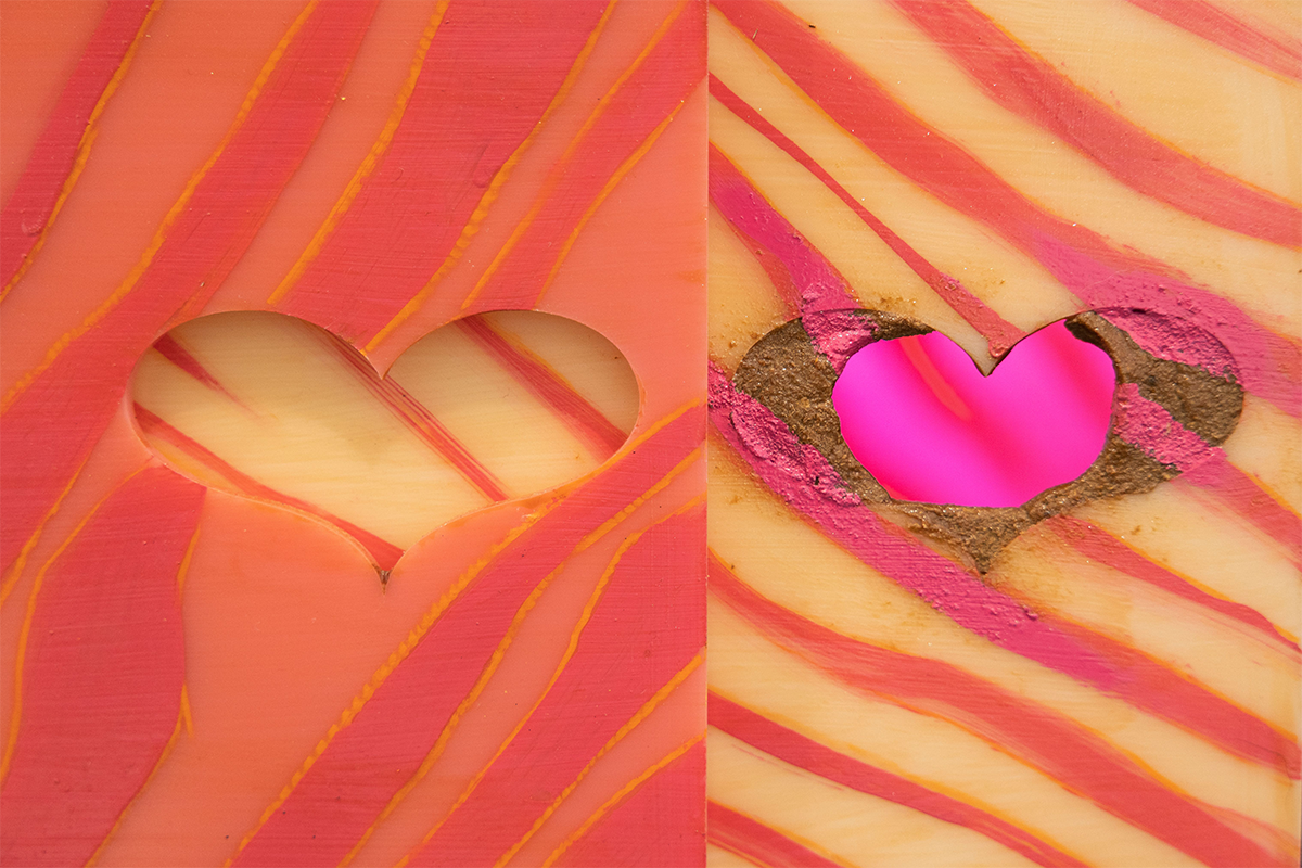 A heart carved out of pink and orange zebra-striped material, juxtaposed with a heart carved from yellow and pink zebra-striped material