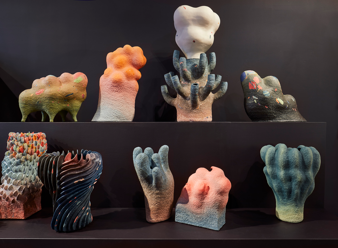 Two shelves of multi-colored ceramic vessels