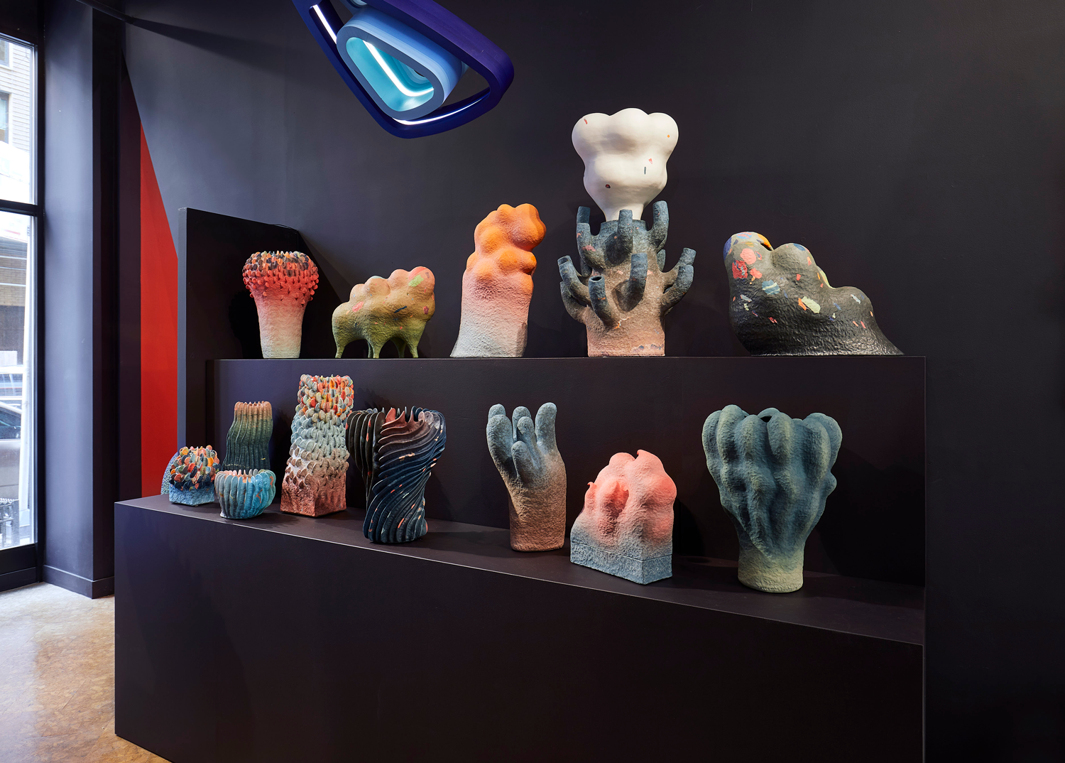 Two shelves of multi-colored ceramic vessels