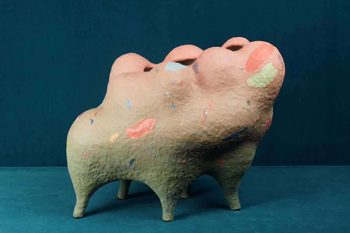 A four-legged pink and green ceramic vessel