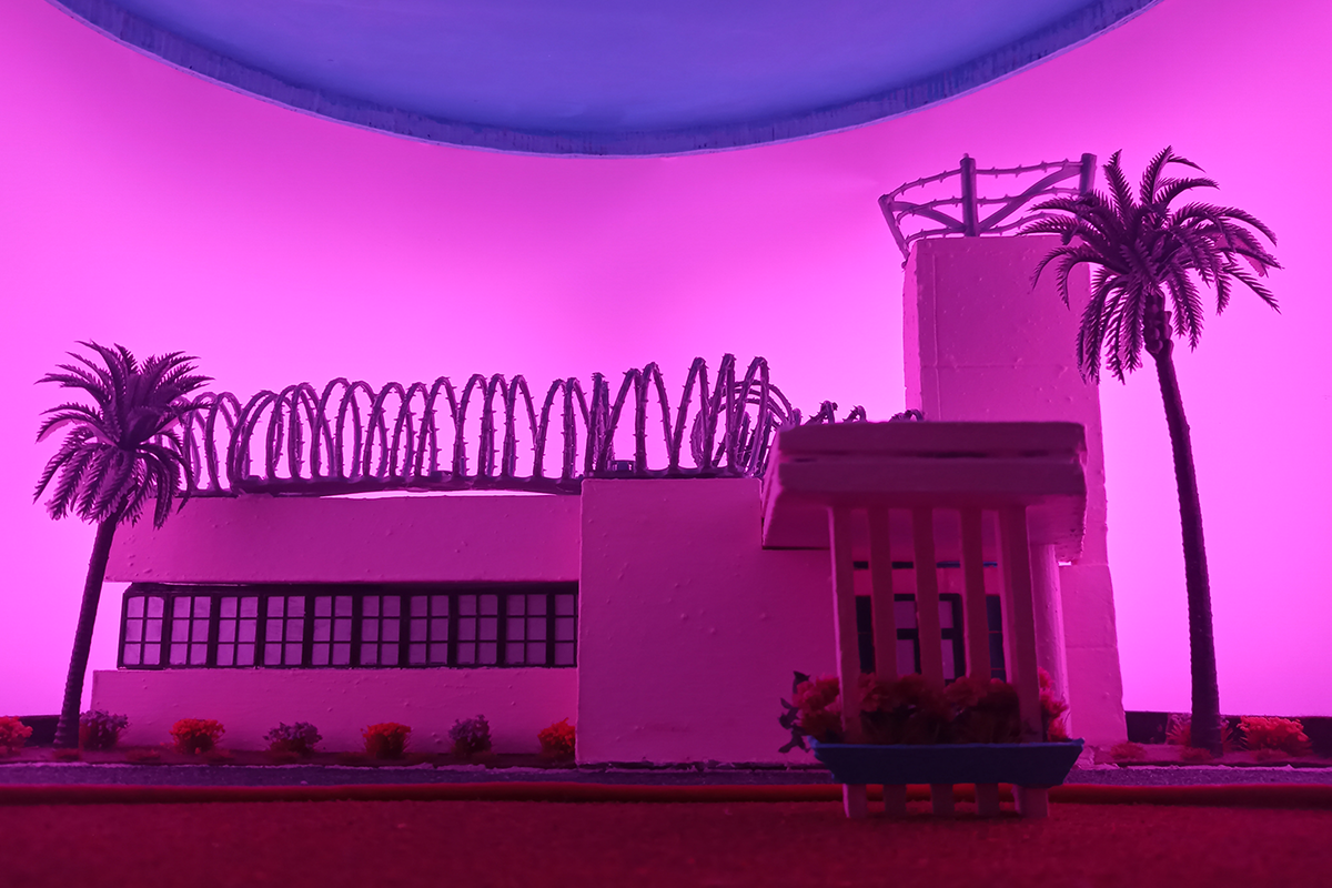 Diorama of a hospital illuminated by pink lighting